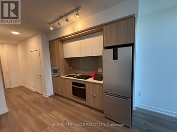 Mississauga (City Centre) condo for rent - A kitchen with wooden cabinets and a stainless steel refrigerator.