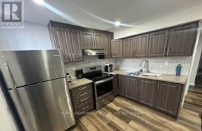 Brampton (Fletcher's Meadow) apartment for rent - A kitchen with wooden cabinets and a stainless steel refrigerator.
