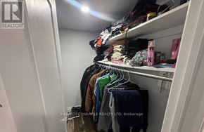 Brampton (Fletcher's Meadow) apartment for rent - A white closet with clothes and shoes on shelves.