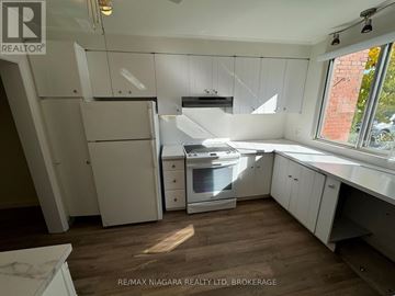 Niagara Falls (Stamford) townhouse for rent - A kitchen with white cabinets and a wooden floor.