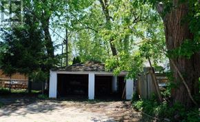 Toronto (Woodbine-Lumsden) apartment for rent - A garage is surrounded by trees and appears to be unused.