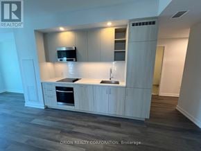 Vaughan (Vaughan Corporate Centre) condo for rent - A modern kitchen with wooden cabinets and a stainless steel range hood.
