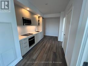 Vaughan (Vaughan Corporate Centre) condo for rent - A kitchen with white cabinets and a wooden floor.