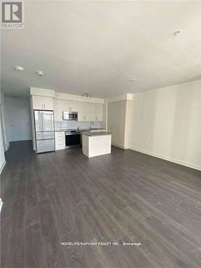 Richmond Hill (Langstaff) condo for rent - A spacious room with wooden flooring and white walls.