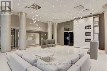 Richmond Hill (Langstaff) condo for rent - A spacious living room with a white sofa and a chandelier.
