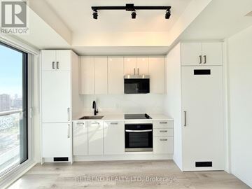Toronto (Kensington-Chinatown) condo for rent - A modern kitchen with white cabinets and appliances, number 11 on the wall.