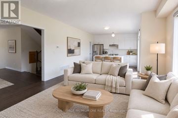 Wasaga Beach apartment for rent - A well-lit living room with a white sofa and a coffee table.