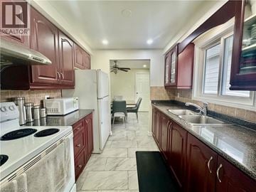 Cambridge apartment for rent - A kitchen with dark wood cabinets and a white stove top oven.