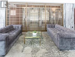 Toronto (Niagara) condo for rent - A living room with a grey couch and a glass coffee table.
