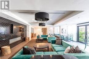 Toronto (Niagara) condo for rent - A modern living room with a green couch and a black chandelier.