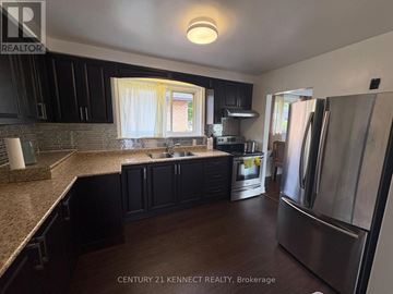 Toronto (Tam O'shanter-Sullivan) apartment for rent - A kitchen with black cabinets and a granite countertop.