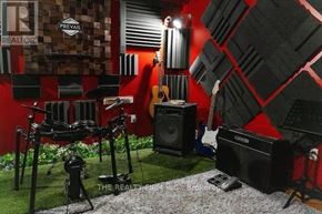 London East (East L) apartment for rent - A room with red walls and a guitar, a speaker, a chair and a drum set.