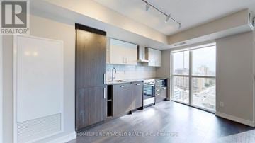 Toronto (Mount Pleasant West) condo for rent - A modern kitchen with dark wood cabinets and a large window.