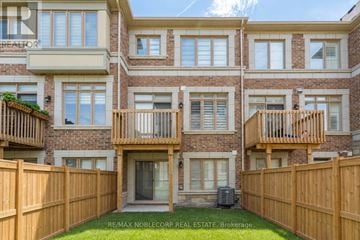 Vaughan (Vellore Village) townhouse for rent - A large brick house with a balcony and a fence.