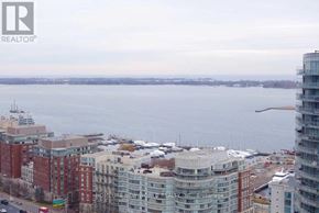 Toronto (Waterfront Communities) condo for rent - A cityscape with buildings and a body of water in the background.