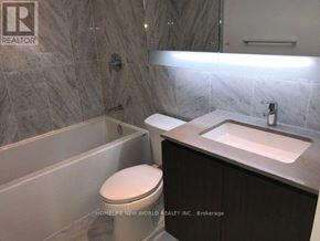 Toronto (Waterfront Communities) condo for rent - A bathroom with a toilet, sink, and mirror.