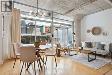 Toronto (Waterfront Communities) condo for rent - A well-lit, modern living room with a dining table and chairs.