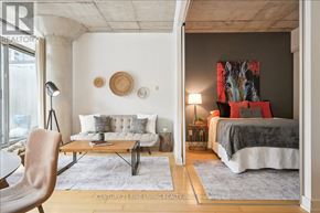 Toronto (Waterfront Communities) condo for rent - A bedroom with a large bed and a chair in the foreground.