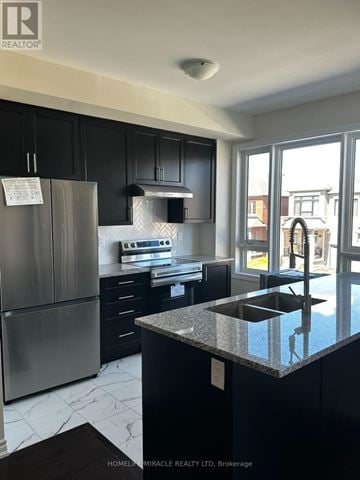 Whitby townhouse for rent - A kitchen with black cabinets and a stainless steel refrigerator.