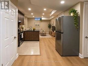 Guelph (Kortright West) apartment for rent - A modern kitchen with a refrigerator, sink, and dining area.