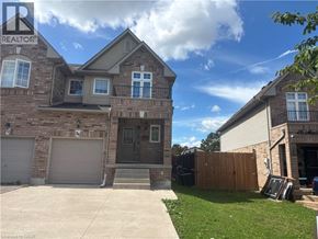 Stoney Creek townhouse for rent - A house with a garage and a driveway in front of it.