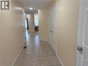 Stoney Creek townhouse for rent - A hallway with tiled flooring and white doors.