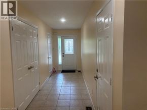 Stoney Creek townhouse for rent - A hallway with white doors and a tiled floor.