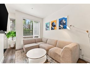 Surrey apartment for rent - A living room with a beige couch, a white table, and three framed pictures on the wall.