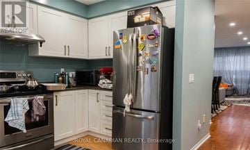 Mississauga (East Credit) townhouse for rent - A kitchen with a stainless steel refrigerator and white cabinets.