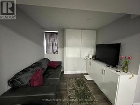 Mississauga (Lisgar) apartment for rent - A living room with a grey couch and a television.