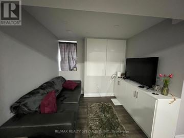 Mississauga (Lisgar) apartment for rent - A living room with a grey couch and a television.