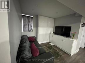 Mississauga (Lisgar) apartment for rent - A living room with a grey couch and a television.