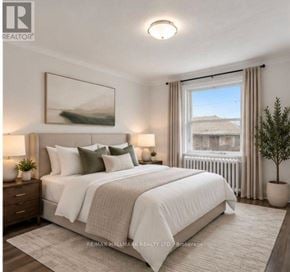 St. Catharines (Downtown) duplex for rent - A bedroom with a large bed, a window with a view, and a painting on the wall.