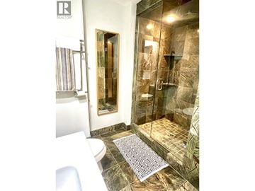 Vancouver apartment for rent - A bathroom with a glass shower stall and a toilet.