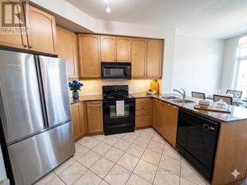 Mississauga (City Centre) condo for rent - A kitchen with wooden cabinets and a stainless steel refrigerator.