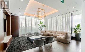 Vaughan (Vaughan Corporate Centre) condo for rent - A modern living room with a large sectional sofa and a coffee table.