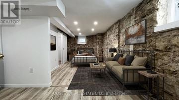 Toronto (High Park North) apartment for rent - A bedroom with a stone wall and a bed with a metal frame.