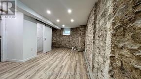 Toronto (High Park North) apartment for rent - A room with a stone wall and wooden flooring.