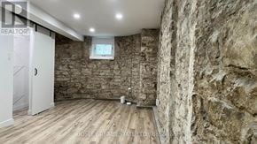 Toronto (High Park North) apartment for rent - A room with a stone wall and wooden flooring.
