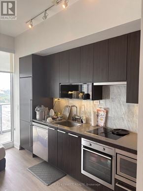 Toronto (Bayview Village) condo for rent - A kitchen with dark brown cabinets and stainless steel appliances.