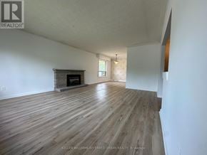 Toronto (Newtonbrook East) apartment for rent - A spacious room with wooden flooring and a fireplace.
