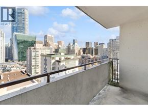 Vancouver apartment for rent - A balcony overlooks a cityscape with buildings of various heights.