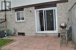 Brampton (Madoc) townhouse for rent - A patio area with a grill and a sliding glass door.