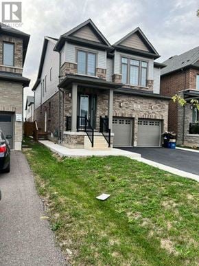 North Dumfries apartment for rent - A house with a grey garage door is in front of a house with a brown garage door.