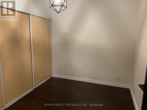 Toronto (Niagara) condo for rent - A room with a wooden floor and a light fixture on the ceiling.