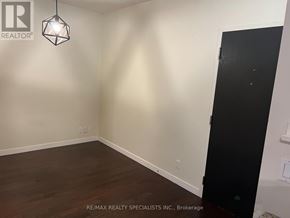 Toronto (Niagara) condo for rent - A room with a wooden floor and a black door.