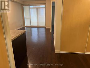 Toronto (Niagara) condo for rent - A room with a wooden floor and a large window.