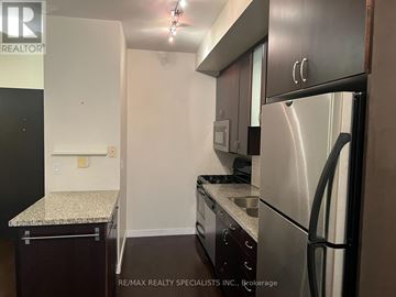 Toronto (Niagara) condo for rent - A kitchen with a stainless steel refrigerator and a granite countertop.
