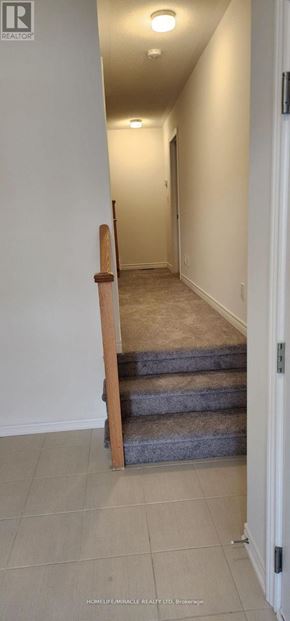 Oshawa (Kedron) townhouse for rent - A hallway with a staircase and a door on the right.