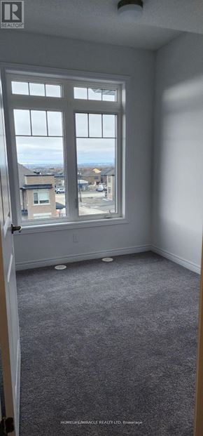 Oshawa (Kedron) townhouse for rent - A room with a large window and carpeted floor.